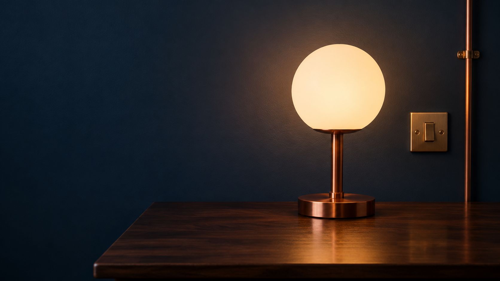 Warm globe lamp on a wooden desk against a navy wall